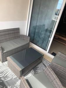 Zimmer mit 2 Stühlen, einem Tisch und einem Fenster in der Unterkunft Appartement T2 lumineux in Frontignan
