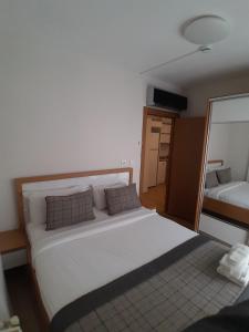 - une chambre avec un grand lit blanc et un miroir dans l'établissement Del Puerto Hotel, à Aliağa