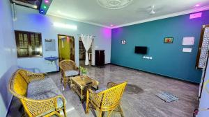 a room with chairs and a table and a blue wall at SK VILLA in Pondicherry