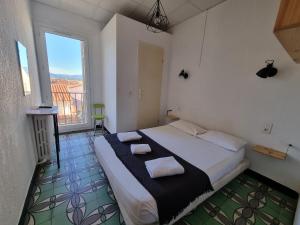 ein Schlafzimmer mit einem Bett mit zwei Handtüchern darauf in der Unterkunft Hotel Le Centre in Le Boulou