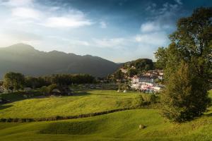una città in un campo verde con montagne sullo sfondo di Swiss Holiday Park Resort a Morschach