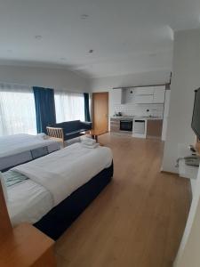 une chambre d'hôtel avec deux lits et une cuisine dans l'établissement Del Puerto Hotel, à Aliağa