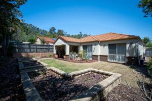 a house with a garden in front of it at family friendly 4 bedroom house close to parks in Gold Coast