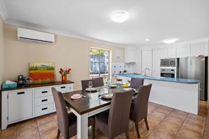 a kitchen and dining room with a table and chairs at family friendly 4 bedroom house close to parks in Gold Coast