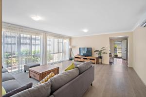 a living room with a couch and a tv at family friendly 4 bedroom house close to parks in Gold Coast