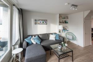 ein Wohnzimmer mit einem Sofa und einem Tisch in der Unterkunft SummerTime Bergen aan Zee in Bergen aan Zee