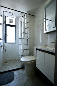 a white bathroom with a toilet and a sink at An Oasis in the heart of Kigali in Kigali