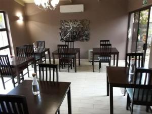 a restaurant with wooden tables and chairs and a dining room at Emangweni Guest House in Vryheid