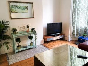 a living room with a flat screen tv and a couch at Pass the Keys Delightful 2 bed apt in Didsbury sleeps 4 in Manchester