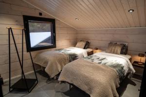 two beds in a room with a window at Villa Ailo in Kittilä
