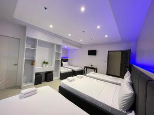 a hotel room with two beds and a tv at Central Block Inn in Bacolod