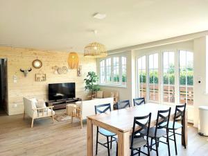 a dining room and living room with a table and chairs at L'Altenberg in Bergheim