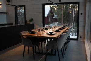 una larga mesa de madera en un restaurante con sillas en Villa Ailo en Kittilä