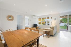 een woonkamer met een houten tafel en een bank bij Sea View Cottage Escape in Middleton