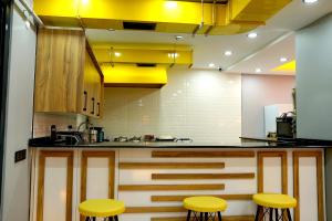 cocina con taburetes amarillos y encimera en GreenWich Hotel, en Avcılar