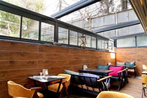 un restaurante con mesas, sillas y ventanas en GreenWich Hotel, en Avcılar