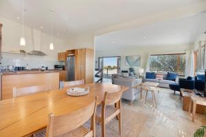 uma cozinha e sala de estar com uma mesa de madeira em Sea View Timber Escape em Middleton