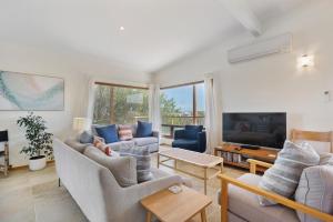 uma sala de estar com dois sofás e uma televisão em Sea View Timber Escape em Middleton