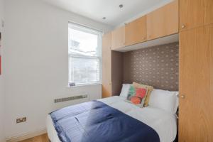 um quarto com uma cama grande e uma janela em The Play Pen - Holborn - by Frankie Says em Londres
