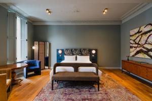 a bedroom with a bed and a desk at Hotel Monastère Maastricht in Maastricht