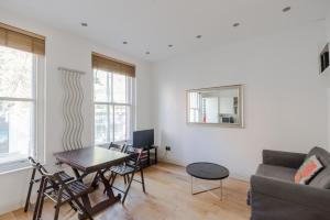 uma sala de estar com um sofá e uma mesa em The Play Pen - Holborn - by Frankie Says em Londres