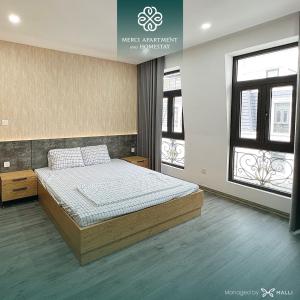 1 dormitorio con 1 cama en una habitación con ventanas en Chuỗi căn hộ Merci Apartment & Homestay - HH Riverside Hai Phong Central en Hai Phong