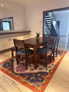 a wooden dining room table and chairs on a rug at Villa Ithaka by Youkoso in Chennai