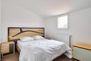 a white bedroom with a large bed and a window at Maison pour 6 adultes et 3 enfants - Terrasse in Noirmoutier-en-l'lle