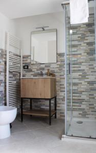 ein Badezimmer mit einem Waschbecken, einem WC und einem Spiegel in der Unterkunft LA LOCANDA DA VITTORIO in Sassa