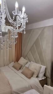 a chandelier is hanging over a bed with pillows at Studio Moderne & Cosy - Vue sur Lac in Torcy