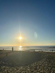 ミッデルケルケにあるRust aan de kustの夕日の浜辺に立つ者