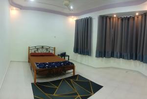 a bedroom with a bed in a room with curtains at Homestay No. 8 in Segamat