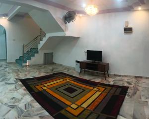 a living room with a staircase and a television at Homestay No. 8 in Segamat