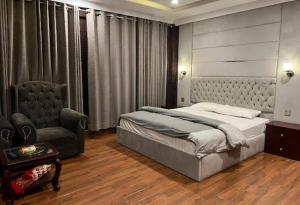um quarto com uma cama e uma cadeira em Waterstones Hotel em Naran