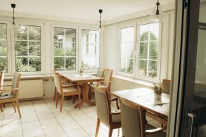 a dining room with tables and chairs and windows at The Resting Place in Lemgo