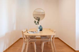 uma mesa de jantar com cadeiras e um espelho em ALTIDO Warm and Inviting flat with balcony no Porto