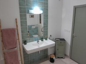 ein Bad mit einem Waschbecken und einem Spiegel in der Unterkunft Les loges de yoff in Ambon