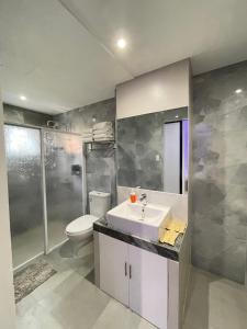 un bagno con lavandino, wc e doccia di Central Block Inn a Bacolod