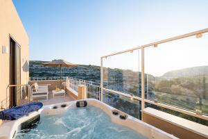 a hot tub on the balcony of a house at Viewpoint Boutique Living in Xlendi