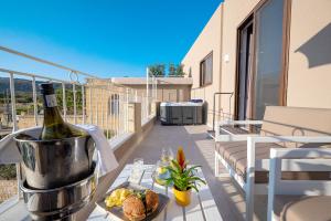 a bottle of wine and a plate of food on a balcony at Viewpoint Boutique Living in Xlendi