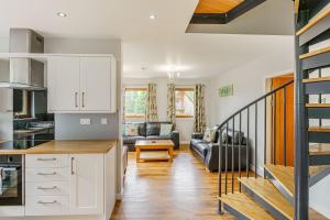 Lord Galloway 33 with Hot Tub في نيوتن ستيوارت: مطبخ وغرفة معيشة مع درج في المنزل +24 صورة