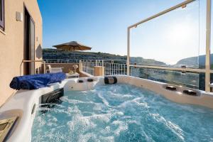 a jacuzzi tub on the balcony of a house at Viewpoint Boutique Living in Xlendi