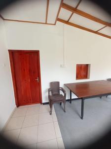 a room with a table and a chair and a door at DAMMI VILLA in Hikkaduwa