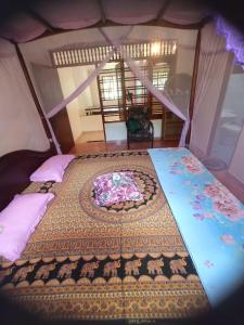 a bedroom with a bed with a blanket on it at DAMMI VILLA in Hikkaduwa