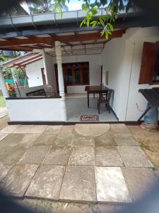 an outdoor patio with a table and a bench at DAMMI VILLA in Hikkaduwa