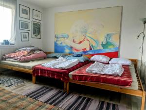 two beds in a room with a painting on the wall at local tax 3 Eur guest for night in Semmering