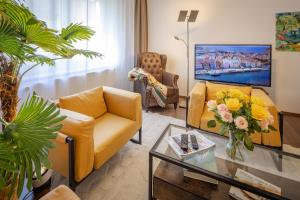 a living room with two yellow couches and a tv at Peter's Choice Germany - BO199A in Bochum