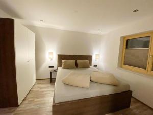 Un dormitorio con una cama grande y una ventana en Alpen Apart Andi, en Zaunhof
