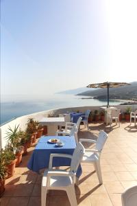 a patio with a table and chairs and the ocean at ARMENA INN in Armenistis