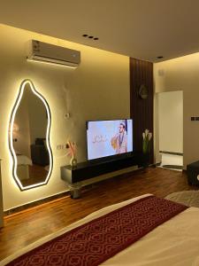 sala de estar con TV y espejo grande en استديو انيق وجميل بدخول ذاتي en Riad